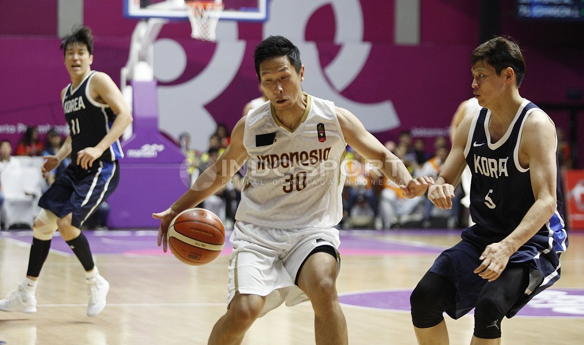 Aksi pebasket Indonesia, Xaverius Prawiro mendrible bola melewati hadangan pemain Korea, Kim Sunhyung (kanan). Copyright: © Herry Ibrahim/Indosport.com