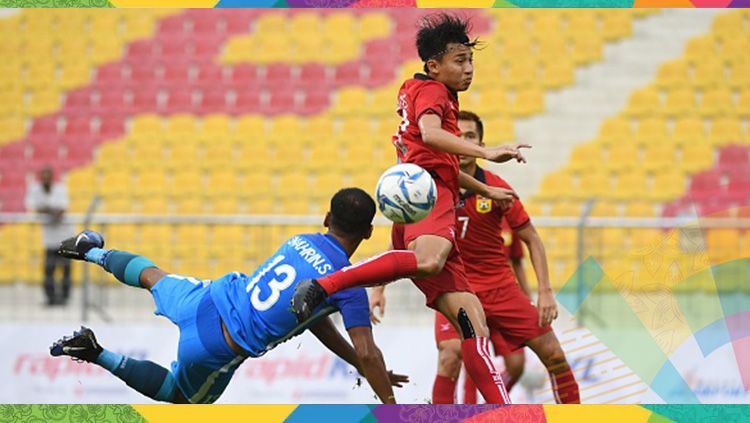 Lounlasy Lathasay (tengah) duel dengan pemain Singapura Muhammad Shahrin Bin Saberin. Copyright: &copy; Getty Images
