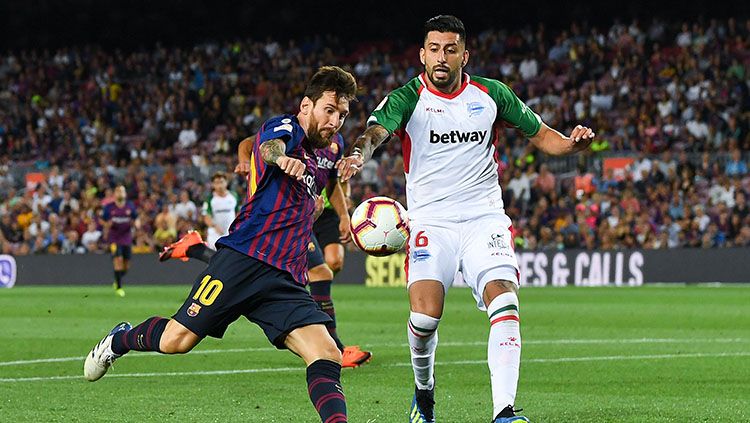 Lionel Messi membawa bola saat Barcelona melawan Alaves. Copyright: © Getty Images