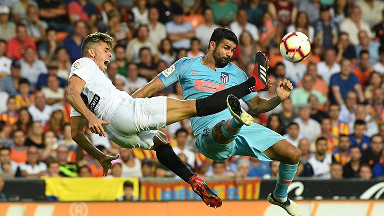 Perebutan bola di lini tengah antara pemain Valencia dengan Atletico Madrid. Copyright: &copy; Getty Images