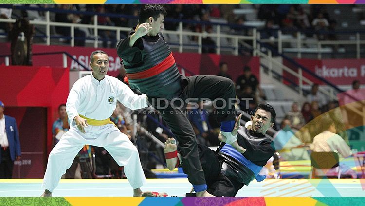 Pesilat Indonesia, Amri Rusdana (sabuk biru) melawan Pesilat Uzbekistan, Nurulla Saidov pada babak 16 besar Kelas F Putra 70kg-75kg di Padepokan Pencak Silat TMII, Rabu (23/08/18). Amri menang 5-0 atas lawannya. Copyright: © INDOSPORT/Herry Ibrahim