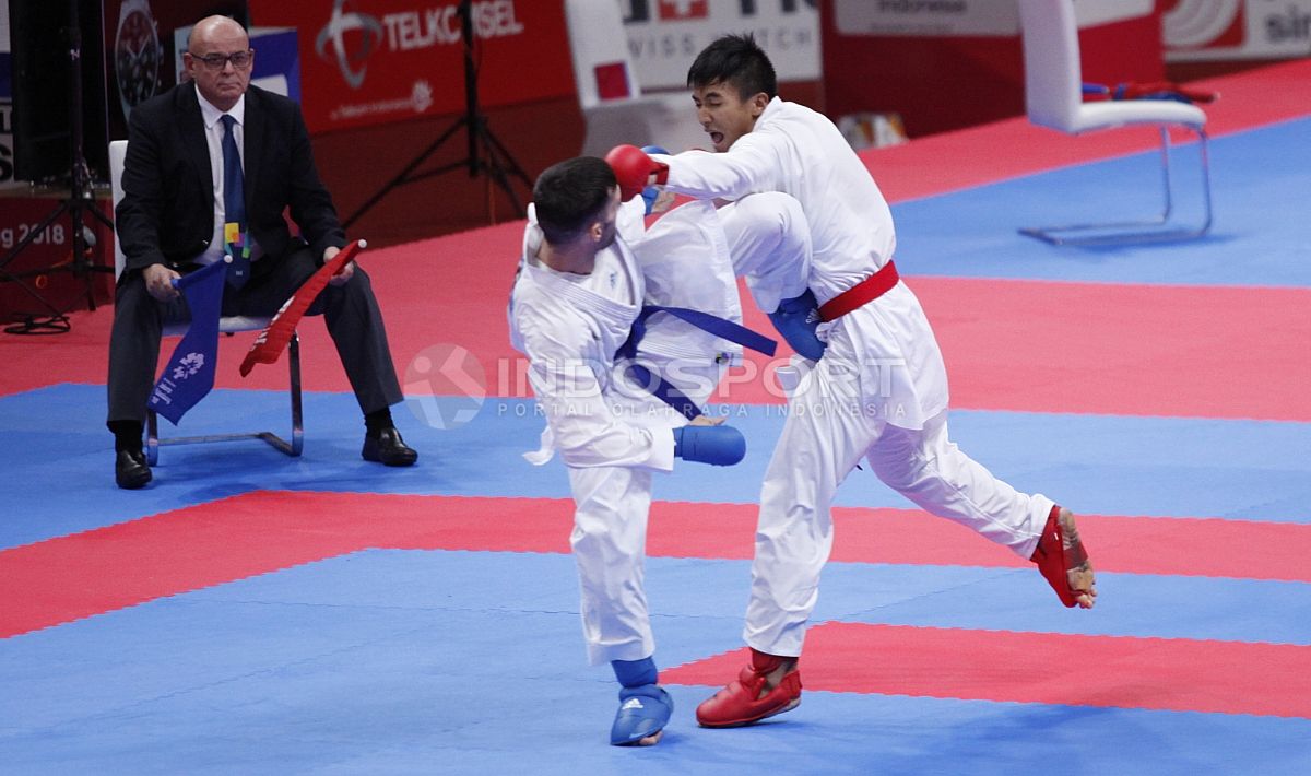 Atlet Karate Indonesia, Rifki Ardian Arrosyid (sabuk merah) melawan atlet Karate Iran, Amir Mahdi Zadeh (sabuk biru) pada babak final Karate kelas Putera -60kg di Plenary Hall JCC, Jakarta, Minggu (26/08/18). Riki menang 9-7 atas lawannya. Copyright: © INDOSPORT/Herry Ibrahim