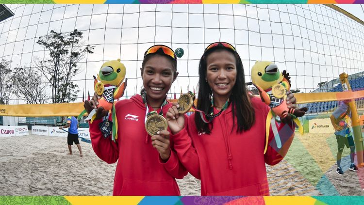 Pevoli pantai putri Indonesia Putu Dini Jasita Utami (kanan) dan Dhita Juliana (kiri) menggigit medali perunggu yang berhasil diraih setelah mengalahkan tiim voli Kazakhstan pada final voli pantai putri Asian Games 2018. Copyright: © INASGOC