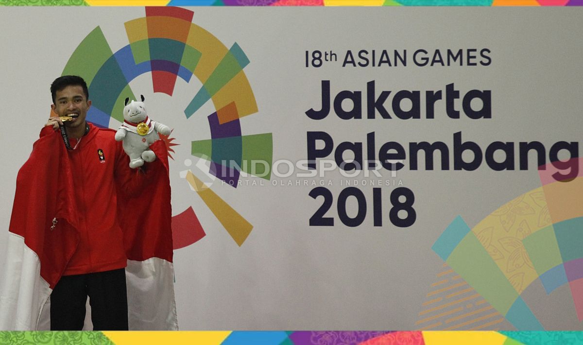 Pesilat Indonesia, Abdul Malik melawan dengan medali emasnya di podium juara. Copyright: © Herry Ibrahim/INDOSPORT