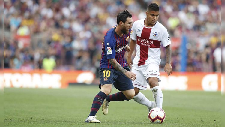 Lionel Messi menggiring bola saat laga Barcelona vs Huesca di La Liga Spanyol. Copyright: © Getty Images