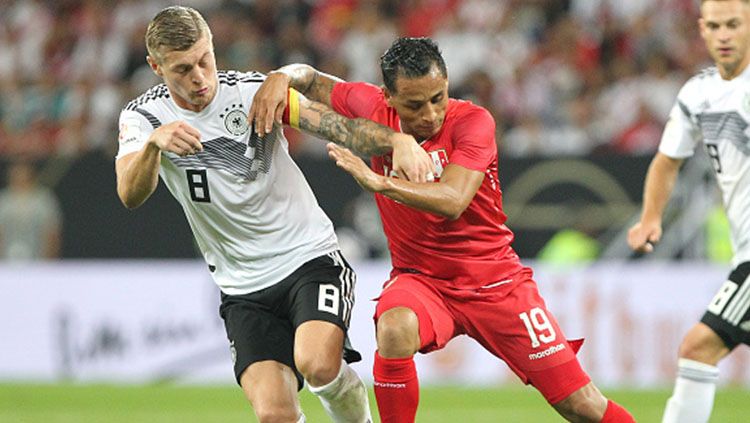 Toni Kroos berduel rebut bola dengan pemain Peru. Copyright: © Getty Images