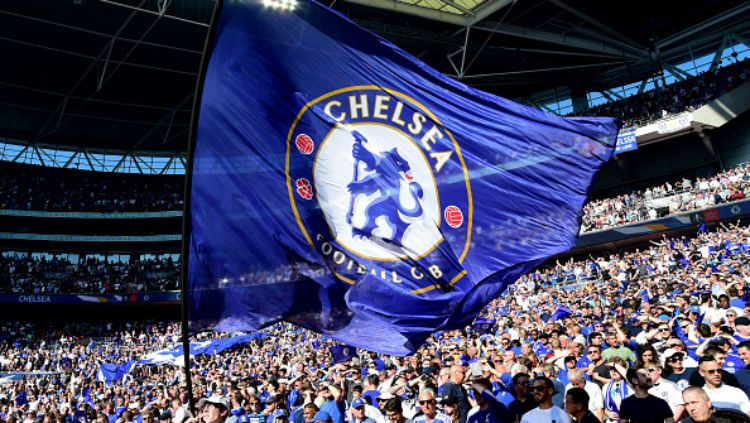 Pendukung Chelsea mengibarkan bendera berlogo klub. Copyright: © INDOSPORT