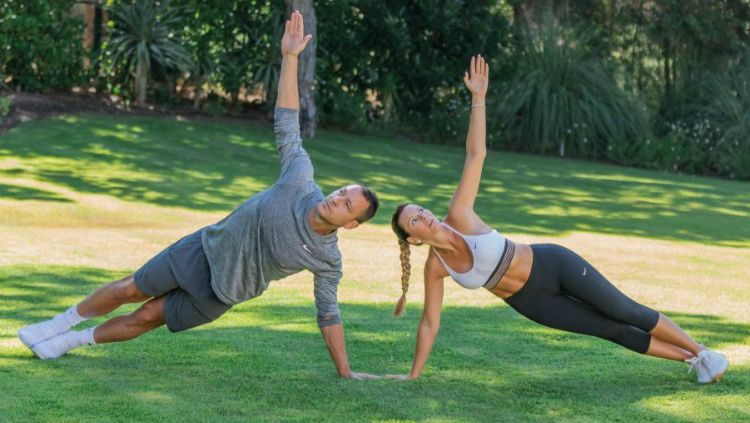 John Terry dan istrinya, Toni melakukan gerakan side plank with rotation. Copyright: © Michael Wicks/The Sun