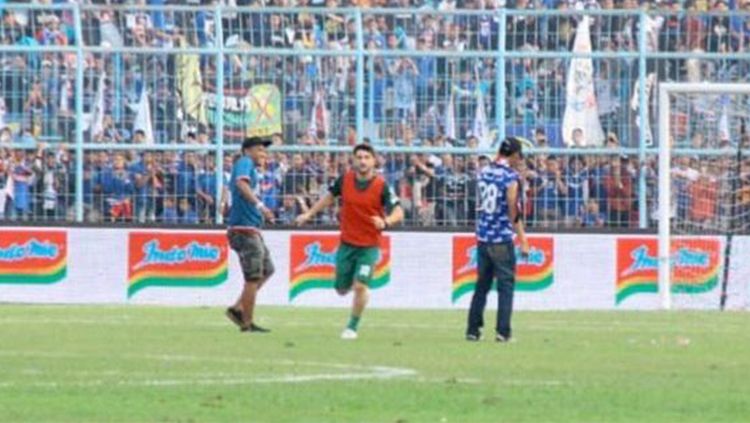 salah satu oknum Aremania masuk lapangan, ganggu Pugliara dan Alfonsius. Copyright: © emosijiwaku.com