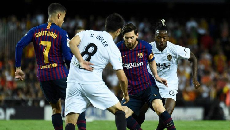 Lionel Messi yang melewati pemain lawan ketika laga Valencia vs Barcelona di La Liga Spanyol, Senin (08/10/18). Copyright: © Getty Images