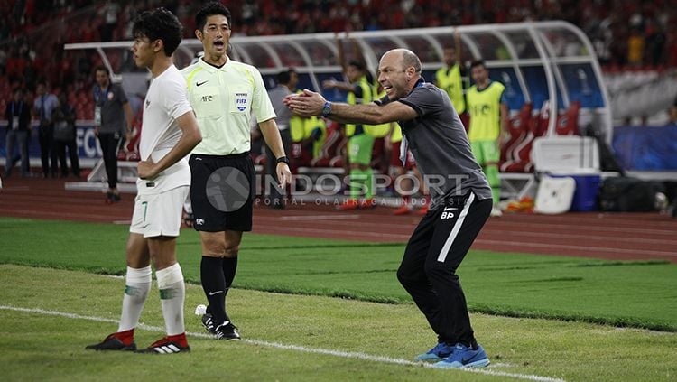 Pelatih Qatar U-19 memberikan instruksi kepada pemainnya dari technical area. Copyright: © Herry Ibrahim/INDOSPORT