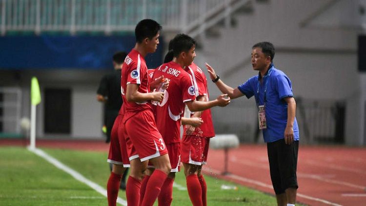 Pelatih Korea Utara U-19, Ri Chol, saat memberikan instruksi anak asuhnya pada laga kontra Irak di Piala Asia U-19 2018. Copyright: © The-AFC.com