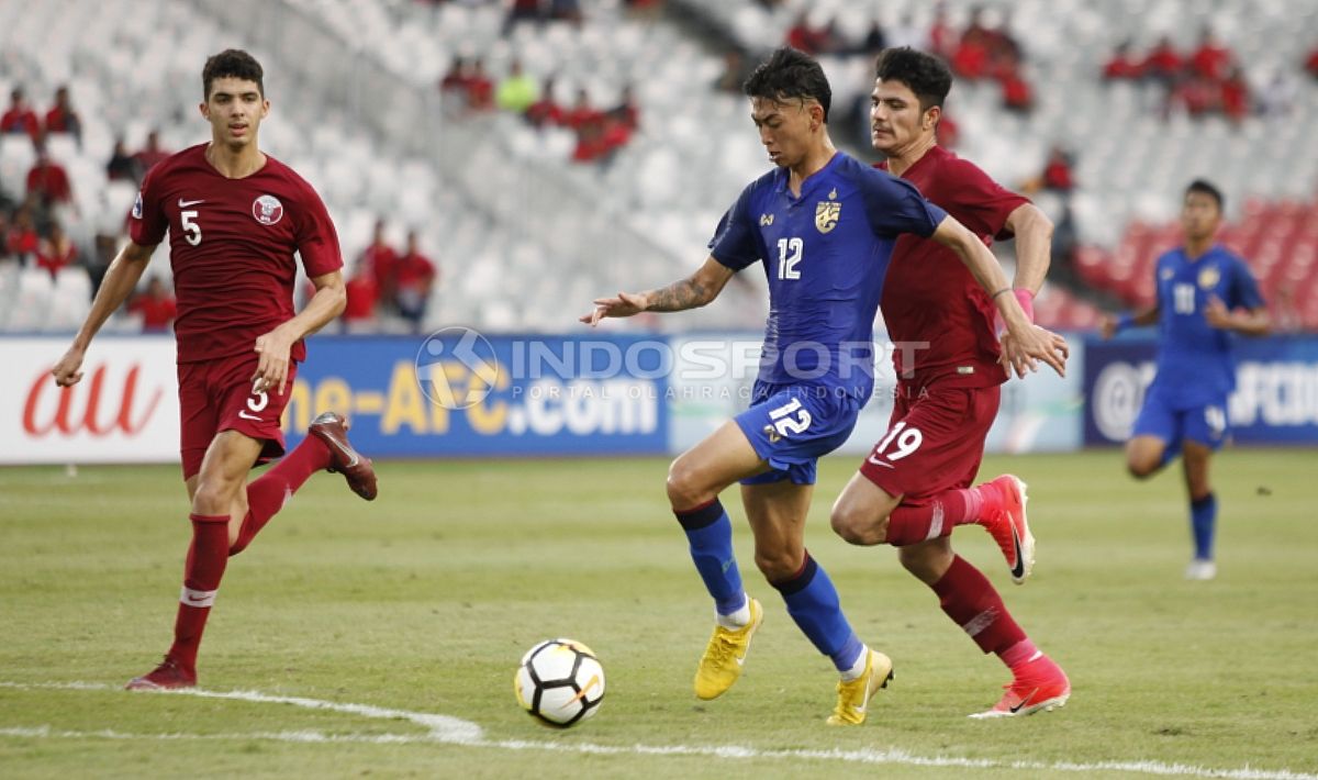 Dua pemain Qatar U-19 kawal ketat lawan tengah menggiring bola. Copyright: © Herry Ibrahim/INDOSPORT