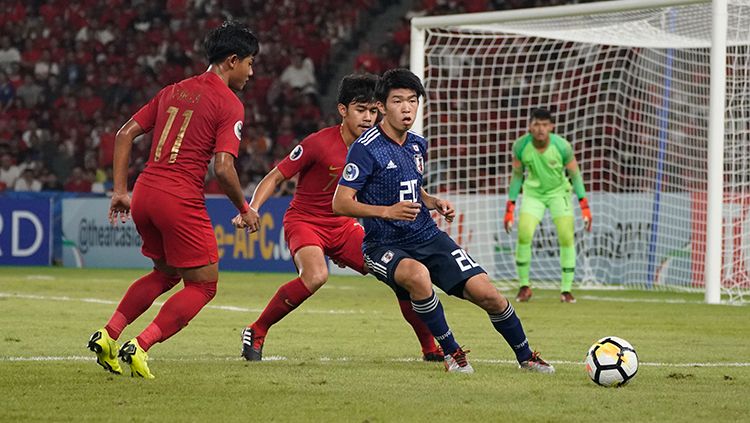 Dua pemain Timnas Indonesia U-19 kawal ketat pemain Jepang. Copyright: © http://photos.the-afc.com