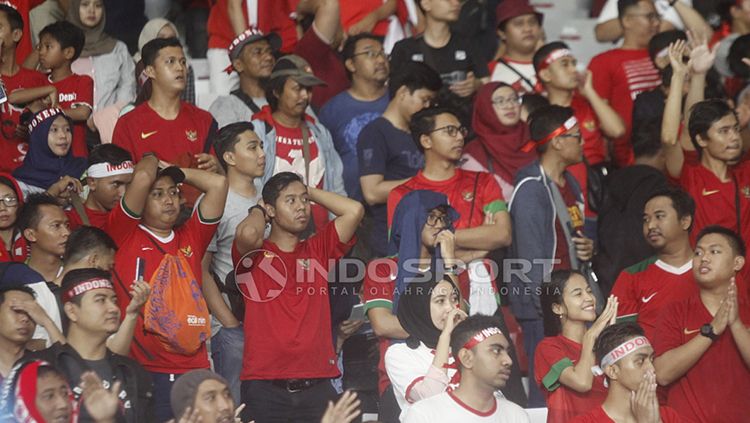 Suporter Timnas Indonesia menunjukkan raut kekecewaan usai Skuat Garuda Nusantara kalah 2-0 dari Jepang U-19. Copyright: © Herry Ibrahim/INDOSPORT