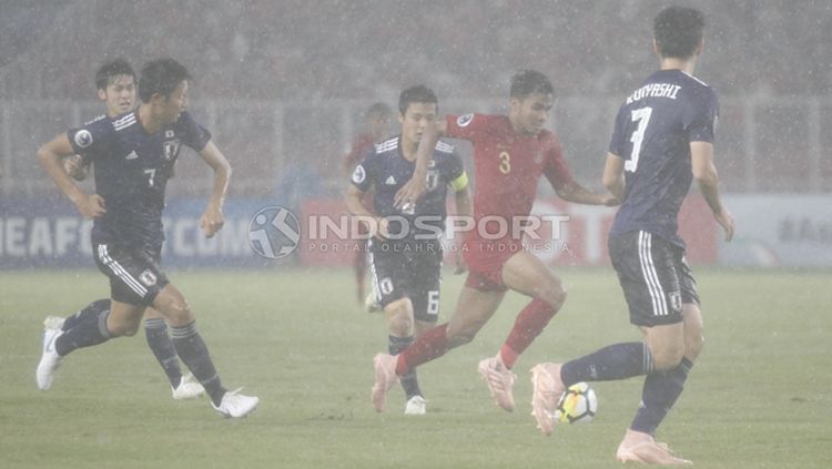 Asnawi Mangkualam Bahar menggiring bola di tengah kepungan pemain Jepang U-19. Copyright: © Herry Ibrahim/INDOSPORT