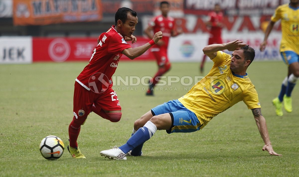 Riko Simanjuntak menghindari jegalan dari pemain Barito Putera. Copyright: © Herry Ibrahim/INDOSPORT