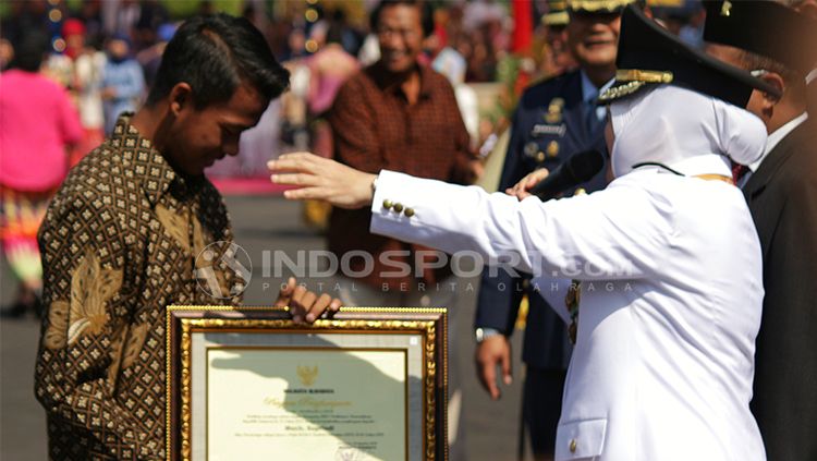 Mochammad Supriadi saat menerima penghargaan dari walikota Surabaya Tri Riamaharini. Copyright: &copy; INDOSPORT/Fitra Herdian