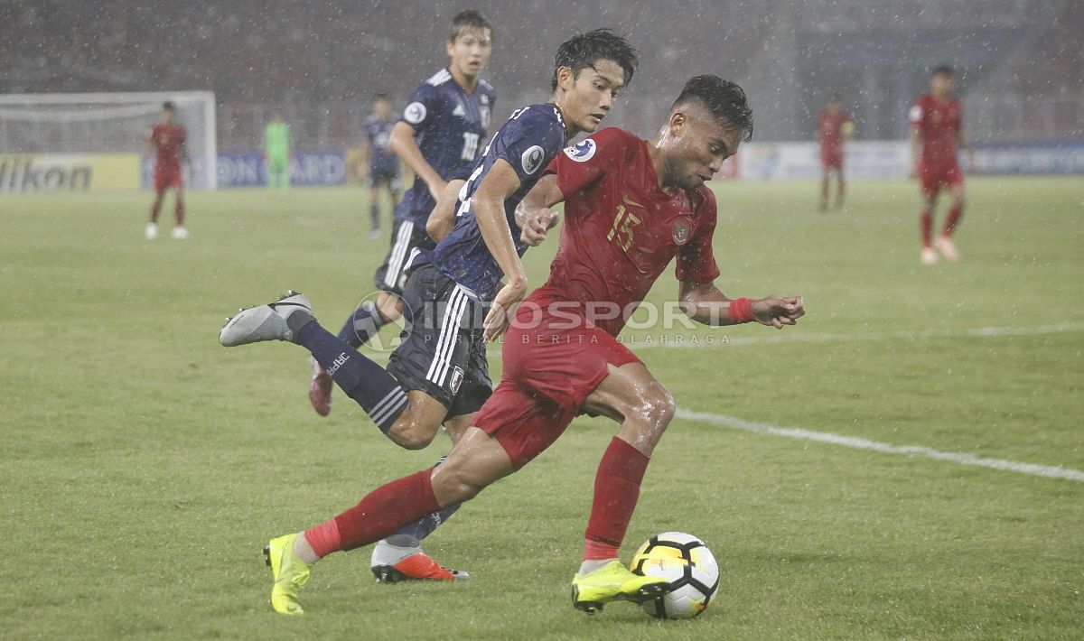 Saddil Ramdani berebut bola dengan pemain Jepang. Copyright: © Herry Ibrahim/INDOSPORT