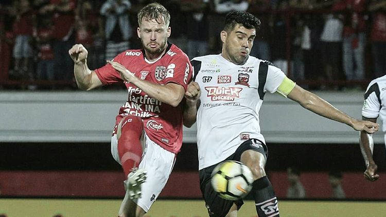 Fabiano Beltrame menghalau untuk menggagalkan aksi pemain Bali United Copyright: © Bali United