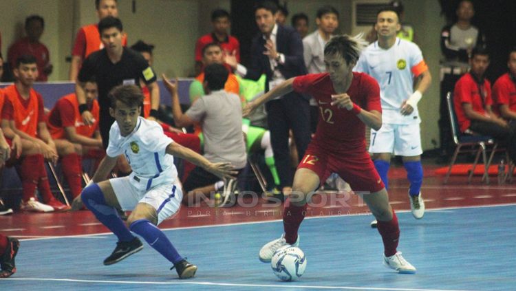 Pemain Indonesia mengontrol bola dari pemain Malaysia Copyright: © Ronald Seger Prabowo/INDOSPORT