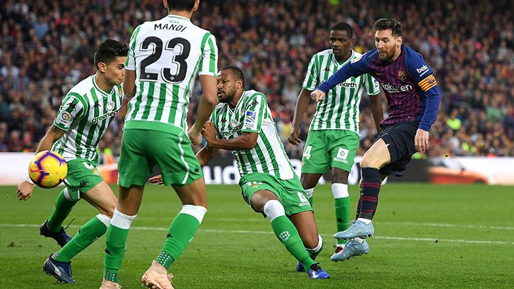 Di tengah hadangan lawan, Lionel Messi melancarkan tendangan ke gawang Real Betis. Copyright: © Alex Caparros/Getty Images