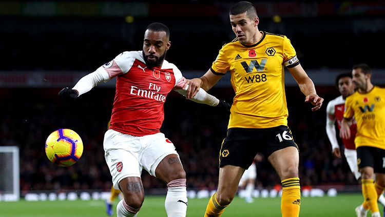 Alexandre Lacazette mencoba melewati adangan pemain Wolverhampton. Copyright: &copy; Clive Rose/Getty Images