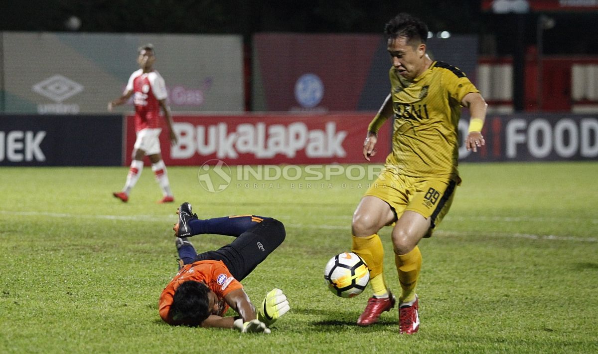 Pemain Bhayangkara FC. Lee Yujun (kanan) mencoba melewati kiper Persipura, Dede Sulaiman. Copyright: © Herry Ibrahim/INDOSPORT