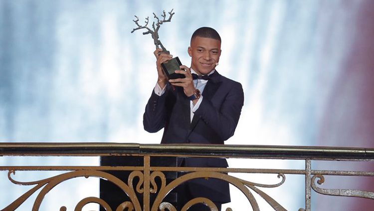 Kylian Mbappe saat menerima piala Trophee Kopa di acara Ballon d'Or. Copyright: © Getty Images