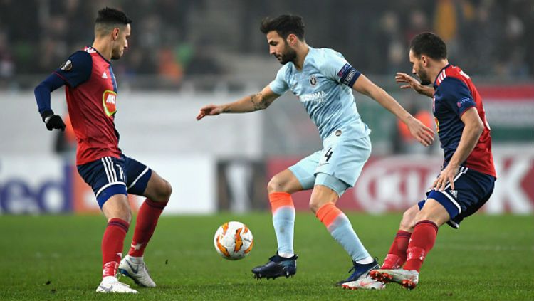 Cecs Fabregas sedang melindungi bola dari rebutan para pemain Vidi FC. Copyright: © Getty Images