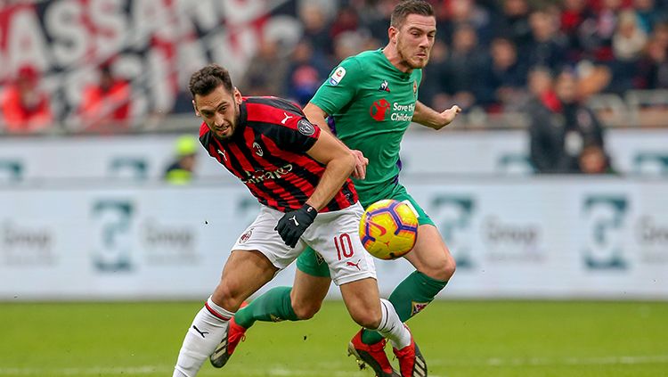 Hakan Calhanoglu (kiri) berduel dengan Jorda Veretout untuk memperebutkan bola. Copyright: © Getty Images