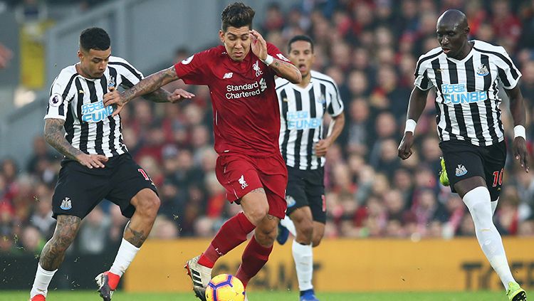 Roberto Firmino menggiring bola di tengah bayang-bayang pemain Newcastle. Copyright: © Jan Kruger/Getty Images