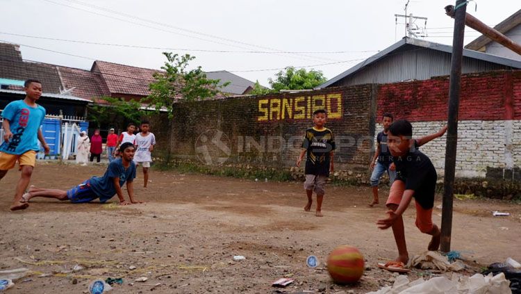 Salah satu lapangan sepak bola desa di Makassar viral karena dengan adanya tulisan San Siro di tembok Copyright: © Wira Wahyu Utama/INDOSPORT