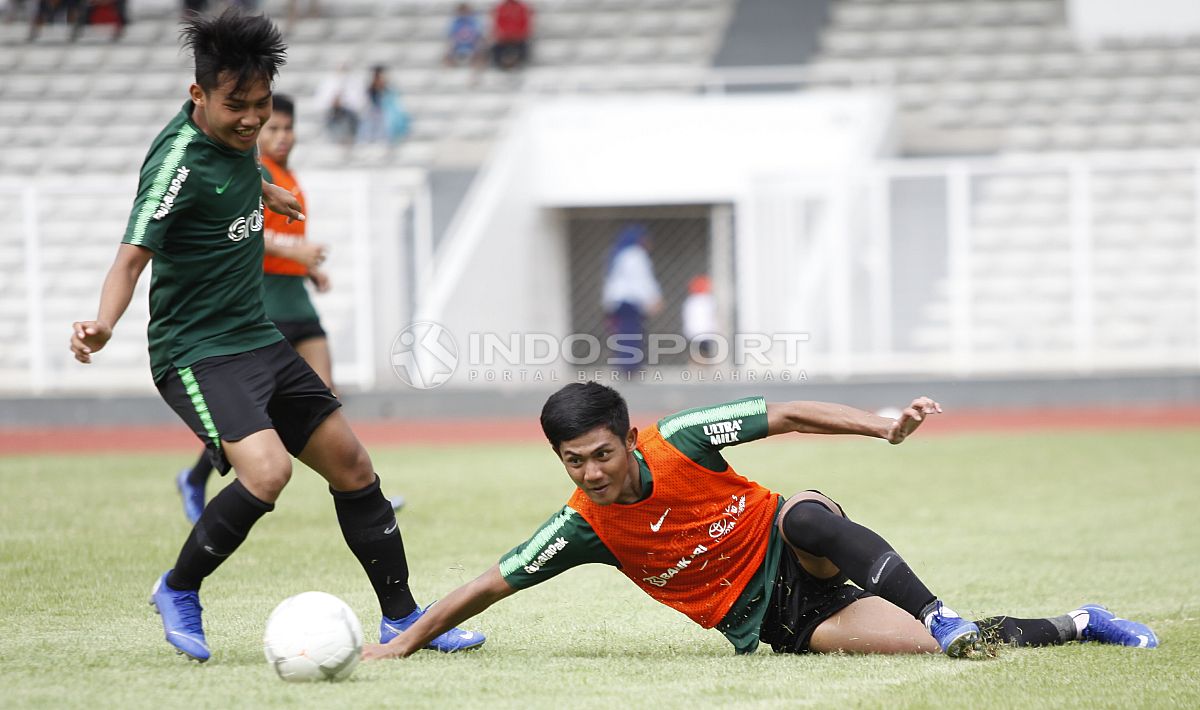 Firza Andika (kanan) terjatuh saat berebut bola dengan Witan Sulaiman. Copyright: © Herry Ibrahim/INDOSPORT