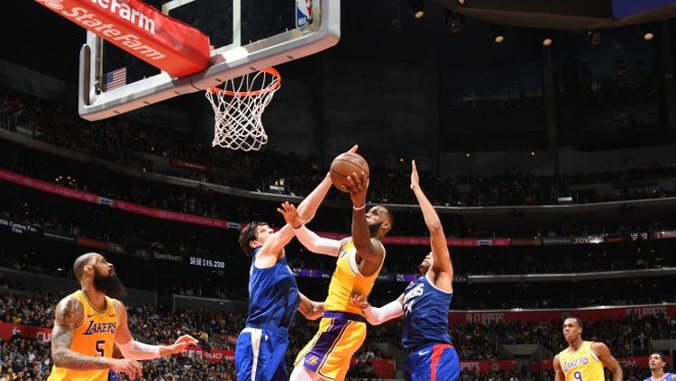Salah satu pemain LA Clippers berusaha gagalkan aksi LeBron James Copyright: © GettyImages