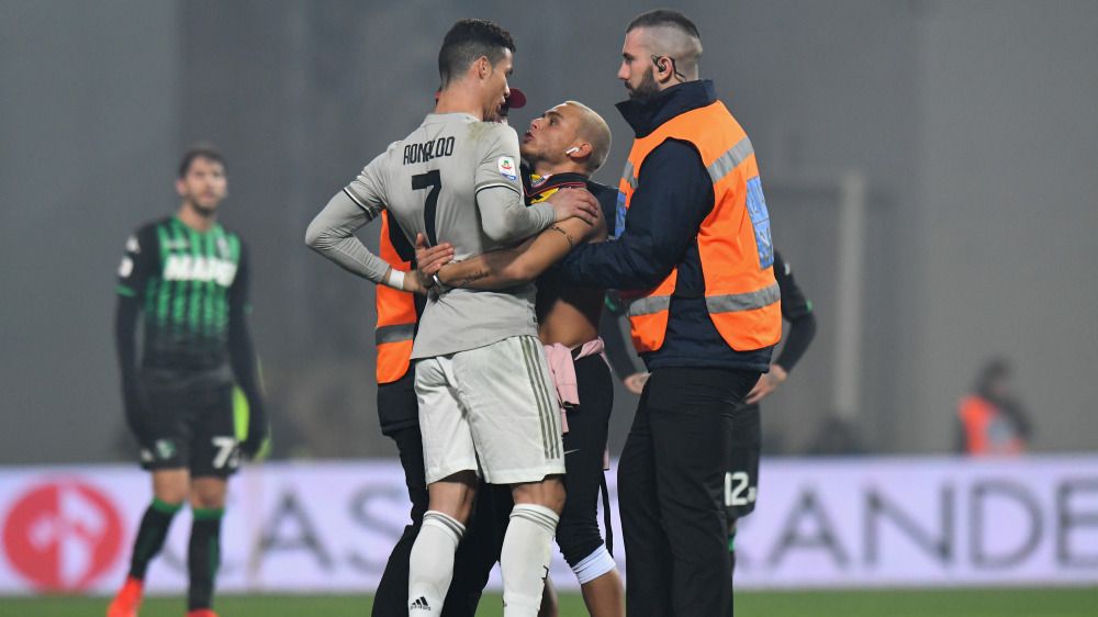 Cristiano Ronaldo dipeluk suporter yang masuk ke lapangan pada saat melawan Sassuolo Copyright: © Getty Images