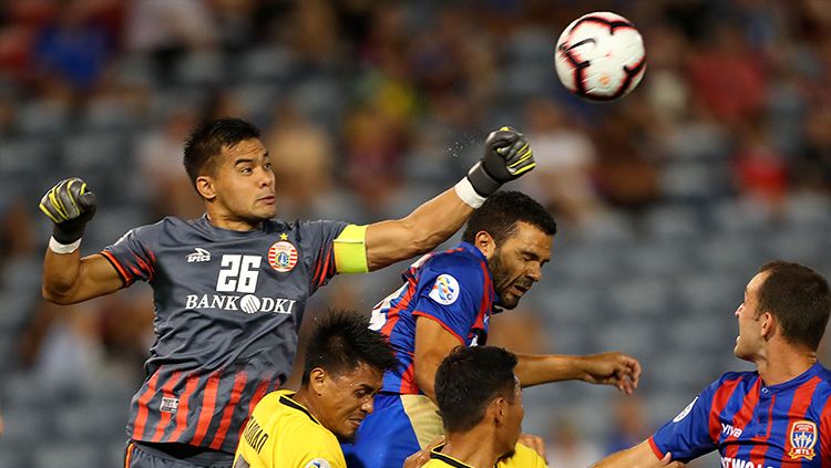 Kiper klub Liga Indonesia Persija Jakarta, Andritany terbang meninju bola untuk menghalau serangan pemain Newcastle Jets. Copyright: © Tony Feder/Getty Images