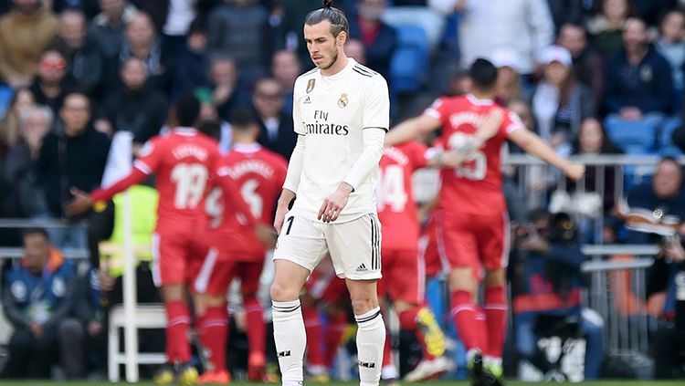 Gareth Bale tertunduk lesu dengan background para pemain Girona merayakan gol Copyright: © GettyImages