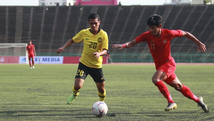 Firza Andika (kanan) duel dengan pemain Malaysia untuk mendapatkan bola Copyright: © PSSI