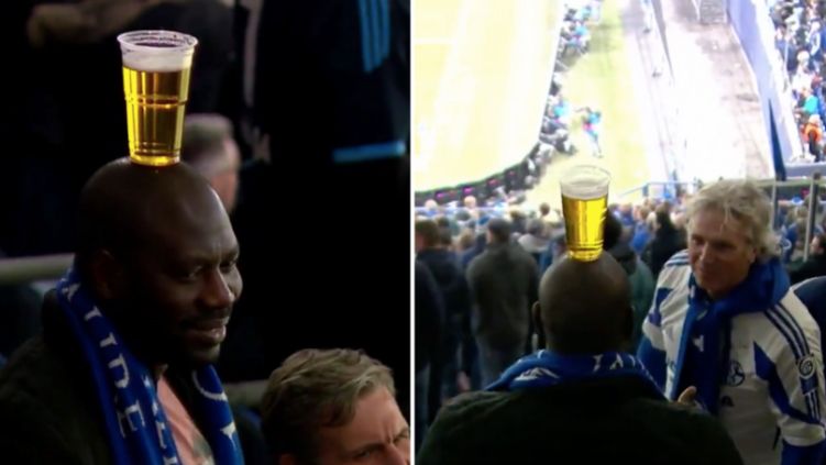 Fans Schalke menyeimbangkan gelas bir di kepalanya. Copyright: © Sportbible