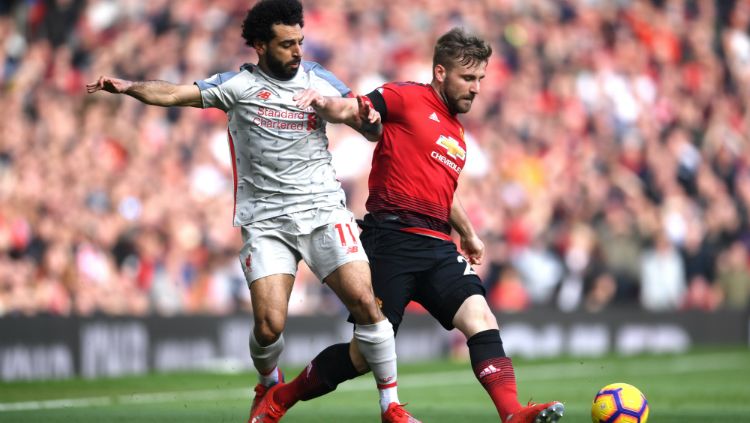 Pemain Liverpool, Mohamed Salah, berusaha merebut bola dari bek kiri Manchester United, Luke Shaw. Copyright: © Getty Images/Laurence Griffiths
