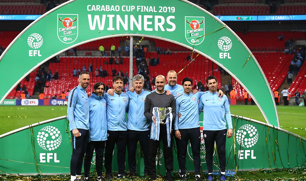Josep Guardiola dan jajarannya melakukan foto bersama trofi Piala Liga Inggris Copyright: © GettyImages