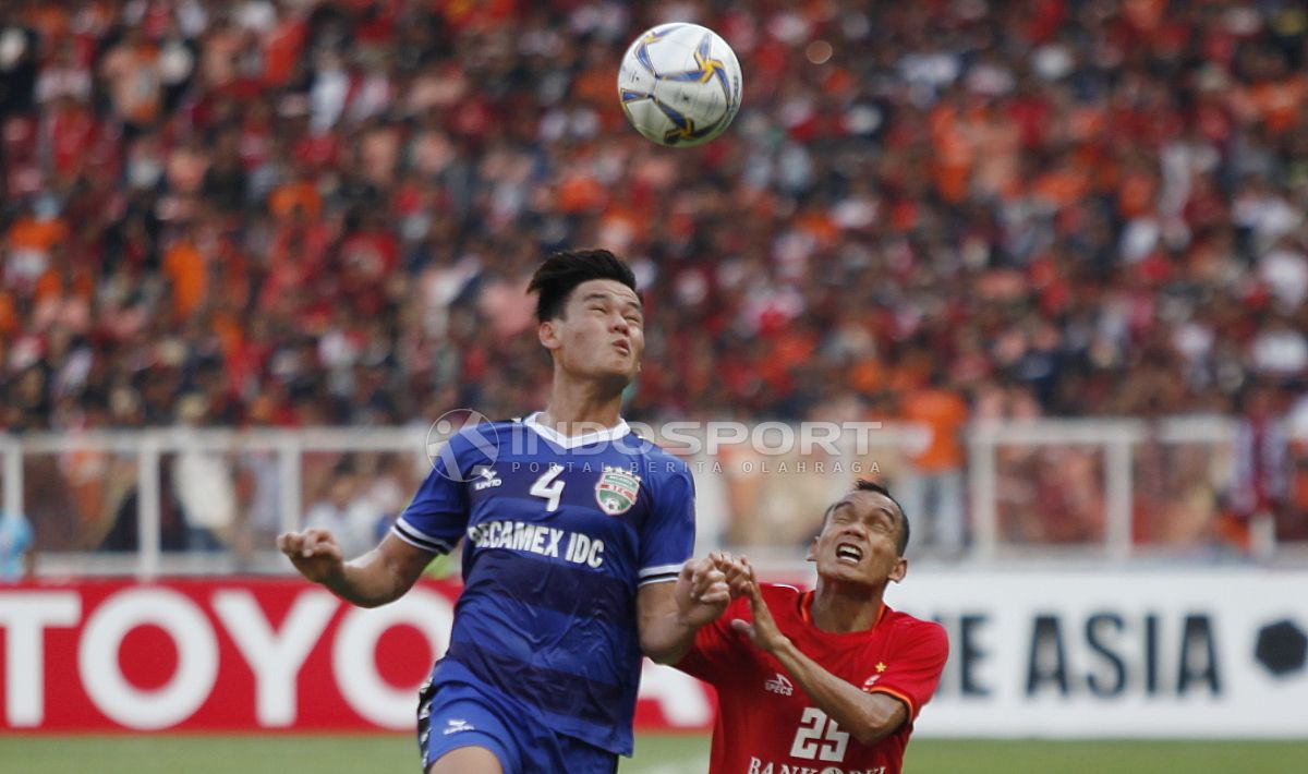 Duel antara Riko Simanjuntak (kanan) dengan pemain Becamex Binh Duong, Ho Tan Tai pada laga perdana Piala AFC 2019 grup G di stadion GBK, Selasa (26/02/18). Copyright: © Herry Ibrahim/INDOSPORT