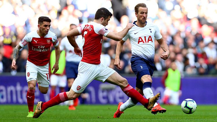 Pergerakkan dari striker Tottenham Hotspur, Harry Kane dicegat oleh bek Arsenal, Sokratis. Copyright: © INDOSPORT