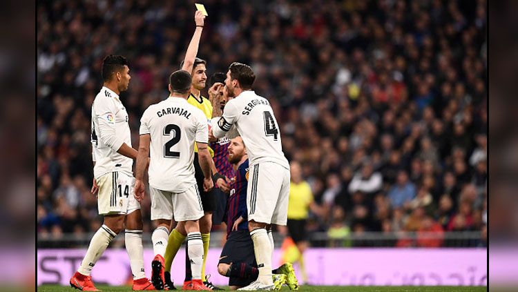 Bek tengah sekaligus kapten Real Madrid, Sergio Ramos melakukan protes terhadap wasit yang memberikannya kartu kuning. Copyright: © INDOSPORT