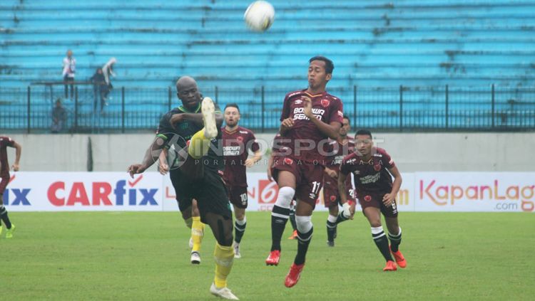 Ok John (kiri) melakukan sapuan bola. Copyright: © Ronald Seger/INDOSPORT