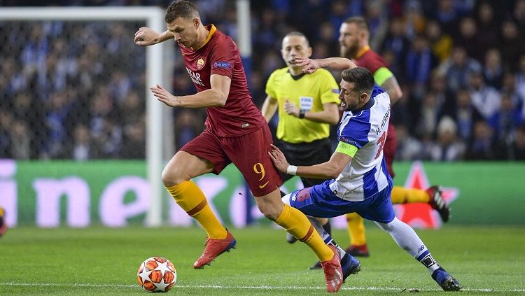 Edin Dzeko (kiri) membawa bola dari kejaran pemain FC Porto. Copyright: © Twitter @ASRomaEN