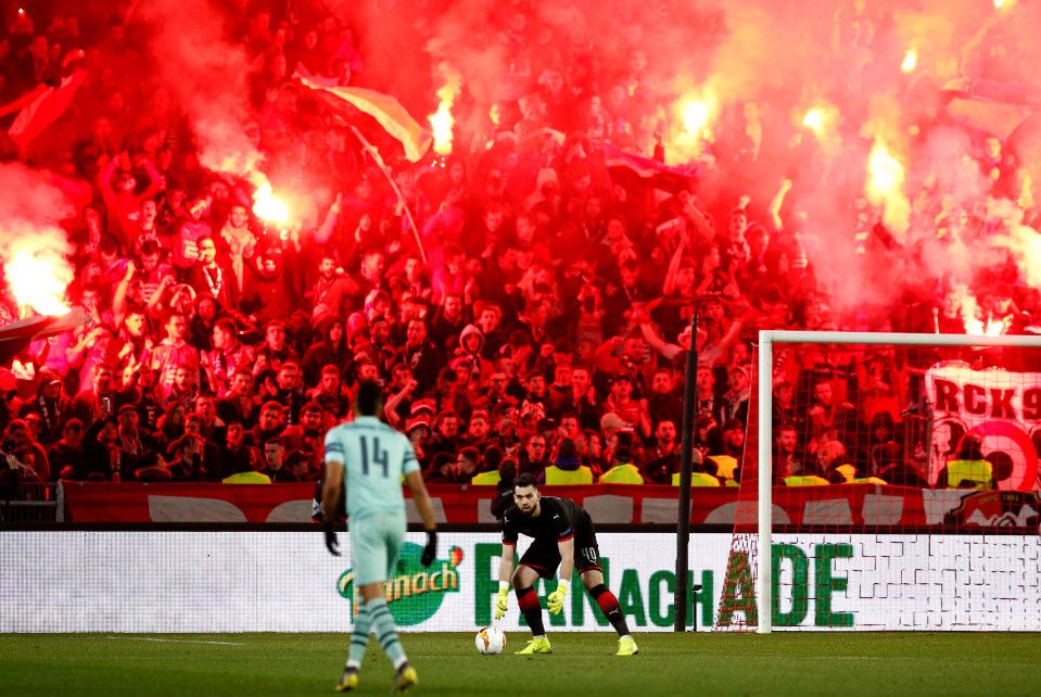 Suporter Arsenal menyalakan flare di pertandingan melawan Rennes pada leg pertama 16 besar Liga Europa 2018/19 di Roazhon Park, Jumat (8/3/19) dini hari WIB. Copyright: © The Sun