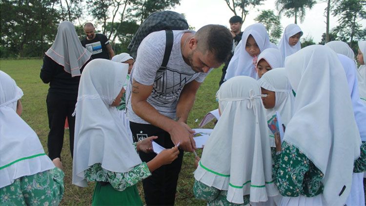 Pemain asing PSIS Semarang, Wallace Costa da Claudir Marini jadi primadona siswa-siswi MI Ma'arif Bandungan yang terletak di sebelah lokasi latihan. Mereka berebut tanda-tangan pemain asal Brasil tersebut. Copyright: © Ronald Seger/INDOSPORT