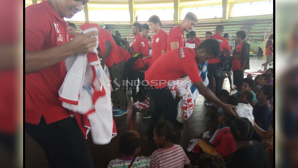 Para Pemain Persipura saat membagikan Jersey untuk para pengungsi. Copyright: © Sudjarwo/Indosport.com